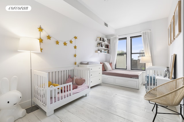 138 Broadway Unit 5G, New York City, NY 11211 - bedroom featuring light wood-type flooring and a crib