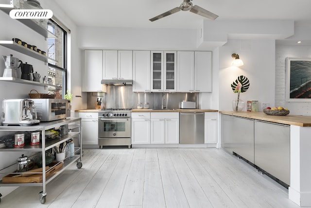 138 Broadway Unit 5G, New York City, NY 11211 - kitchen with appliances with stainless steel finishes, a ceiling fan, light wood finished floors, and white cabinets