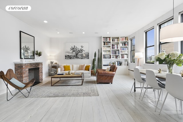 138 Broadway Unit 5G, New York City, NY 11211 - living room with light wood finished floors, recessed lighting, a brick fireplace, and built in shelves