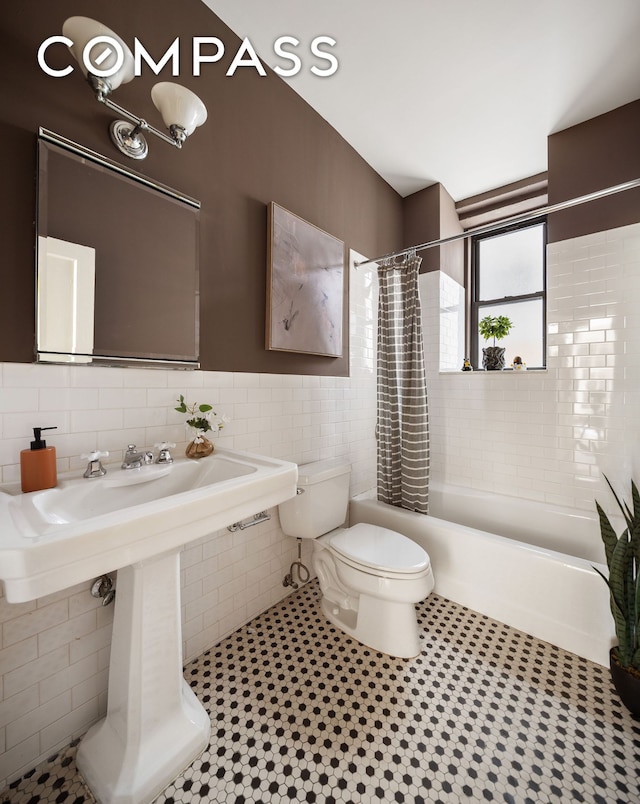 270 Riverside Dr Unit 2C, New York City, NY 10025 - bathroom with toilet, tile walls, shower / bathtub combination with curtain, and a sink