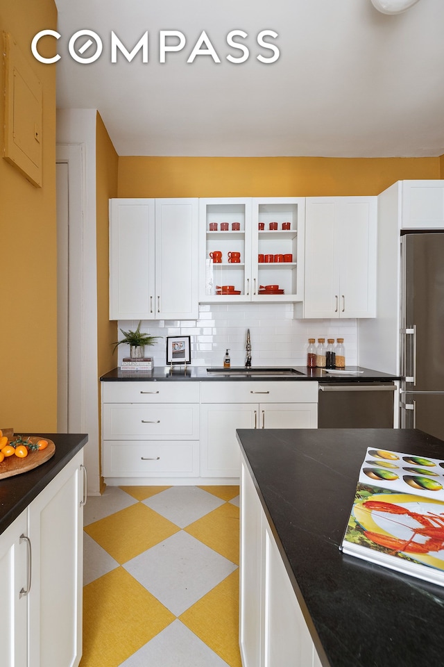 270 Riverside Dr Unit 2C, New York City, NY 10025 - kitchen with high end fridge, light floors, stainless steel dishwasher, dark countertops, and white cabinets