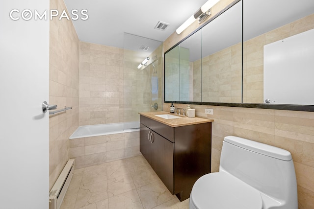 40 W 116th St Unit B302, New York City, NY 10026 - full bathroom with a baseboard heating unit, toilet, tile walls, vanity, and marble look tiles