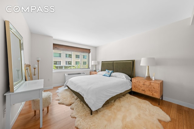 40 W 116th St Unit B302, New York City, NY 10026 - bedroom featuring wood finished floors, baseboards, and a wall mounted AC