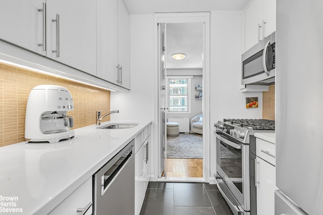 300 E 40th St Unit 20S, New York City, NY 10016 - kitchen featuring stainless steel appliances, a sink, light countertops, tasteful backsplash, and white cabinets