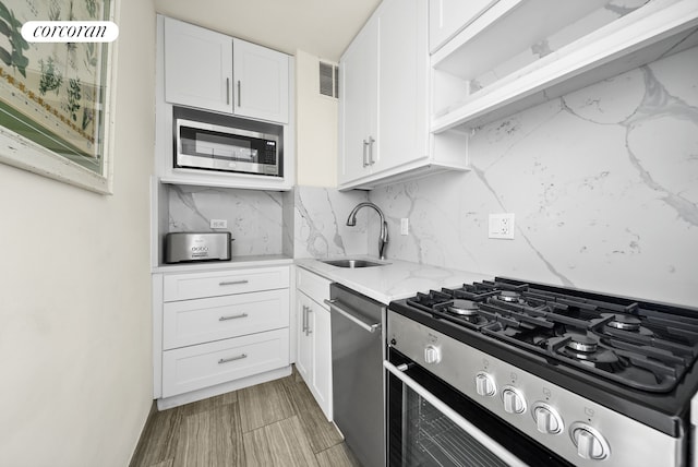 201 E 37th St Unit 4Fg, New York City, NY 10016 - kitchen with appliances with stainless steel finishes, a sink, white cabinetry, and tasteful backsplash