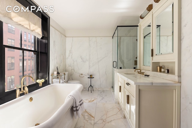 211 Elizabeth St Unit 3S, New York City, NY 10012 - bathroom featuring marble tiled floors, a freestanding tub, vanity, and a marble finish shower