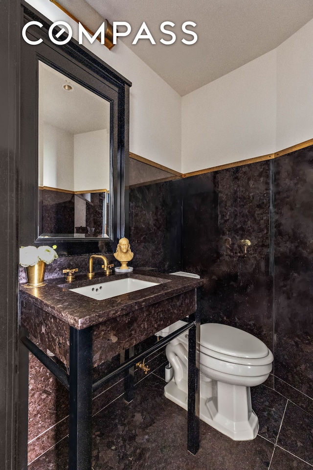 211 Elizabeth St Unit 3S, New York City, NY 10012 - bathroom featuring tile walls and a wainscoted wall