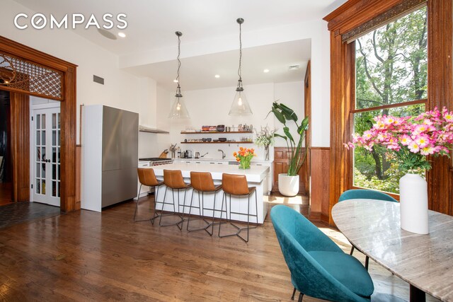 430 W 147th St, New York City, NY 10031 - kitchen with open shelves, light countertops, dark wood-type flooring, wainscoting, and hanging light fixtures
