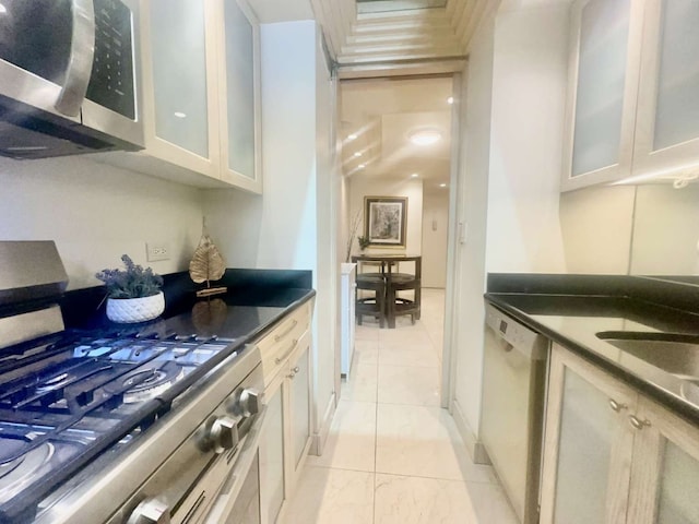 35 E 38th St Unit 3C, New York City, NY 10016 - kitchen with stainless steel appliances, dark countertops, glass insert cabinets, and white cabinets
