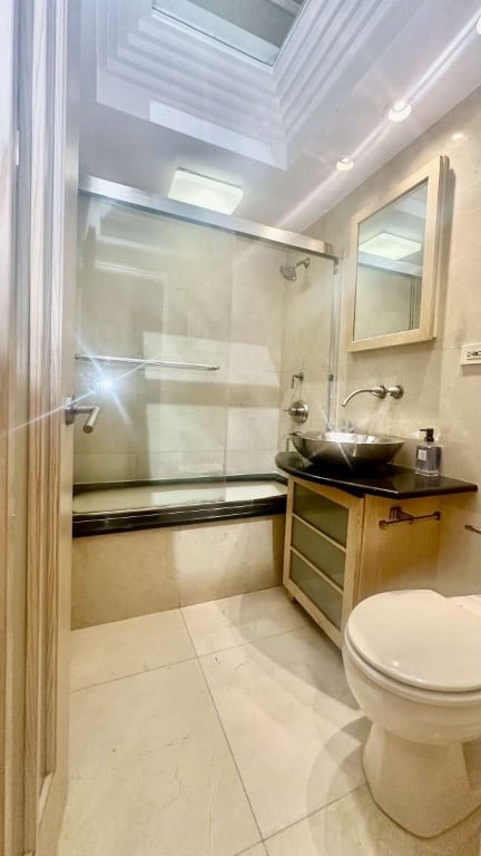 35 E 38th St Unit 3C, New York City, NY 10016 - bathroom with shower / bath combination with glass door, toilet, vanity, and tile patterned floors