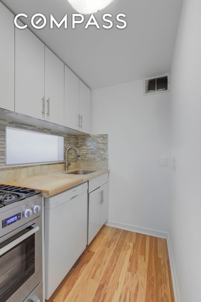 35 E 38th St Unit 12B, New York City, NY 10016 - kitchen with dishwasher, stainless steel range with gas stovetop, decorative backsplash, light countertops, and light wood finished floors