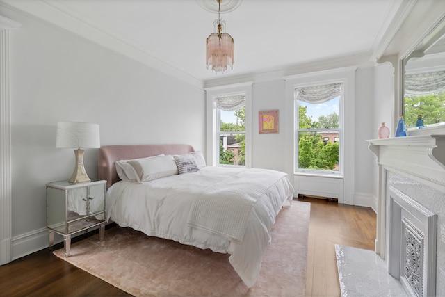 146 St Johns Place, New York City, NY 11217 - bedroom with wood finished floors, multiple windows, ornamental molding, a chandelier, and a fireplace with flush hearth