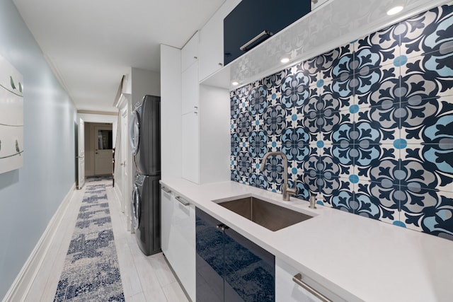 146 St Johns Place, New York City, NY 11217 - kitchen with estacked washer and dryer, a sink, light countertops, and white cabinetry
