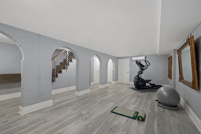 146 St Johns Place, New York City, NY 11217 - workout room featuring a wall mounted AC, arched walkways, wood finished floors, and baseboards