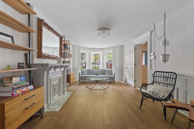 146 St Johns Place, New York City, NY 11217 - living area with a high end fireplace, a decorative wall, wood finished floors, and a wainscoted wall