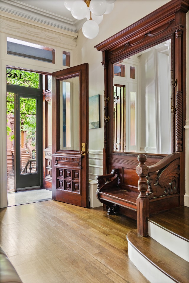 146 St Johns Place, New York City, NY 11217 - foyer entrance featuring wood finished floors, crown molding, and a chandelier