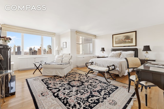 322 W 57th St Unit 33U, New York City, NY 10019 - bedroom with light wood-style floors, crown molding, and a view of skyline