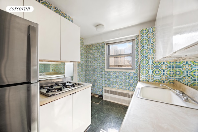 360 E 72nd St Unit C2003, New York City, NY 10021 - kitchen with freestanding refrigerator, radiator heating unit, gas stovetop, white cabinets, and light countertops