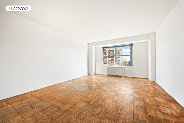 360 E 72nd St Unit C2003, New York City, NY 10021 - empty room with radiator heating unit and baseboards
