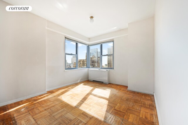 360 E 72nd St Unit C2003, New York City, NY 10021 - spare room featuring a view of city and radiator heating unit