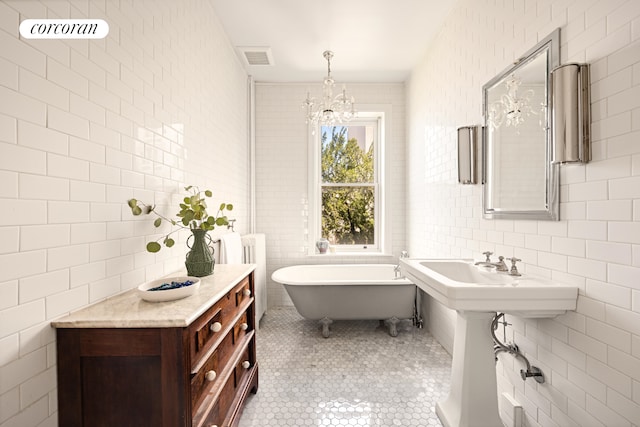 151 Herkimer St, New York City, NY 11216 - bathroom featuring tile walls, a freestanding bath, a chandelier, tile patterned floors, and radiator heating unit