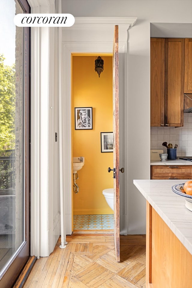 151 Herkimer St, New York City, NY 11216 - kitchen with brown cabinets, light countertops, tasteful backsplash, wall chimney range hood, and cooktop