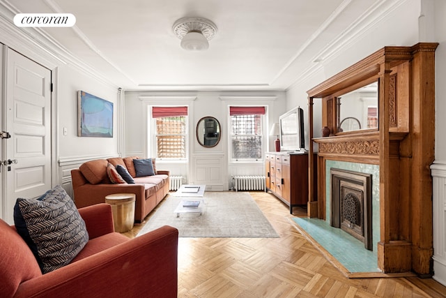 151 Herkimer St, New York City, NY 11216 - living room featuring radiator, a tray ceiling, a fireplace, wainscoting, and ornamental molding
