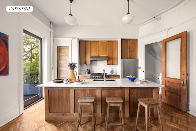 151 Herkimer St, New York City, NY 11216 - kitchen featuring freestanding refrigerator, under cabinet range hood, light countertops, decorative backsplash, and brown cabinets