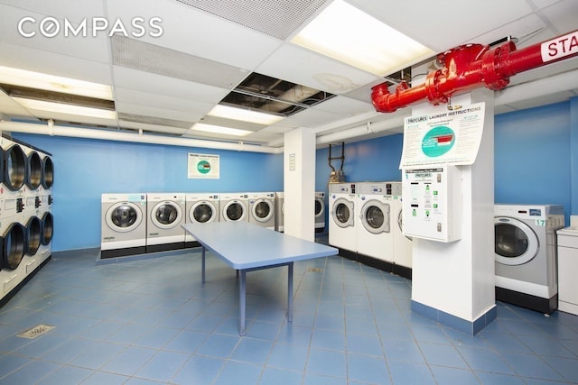 80 Park Ave Unit 12F, New York City, NY 10016 - shared laundry featuring separate washer and dryer and dark tile patterned flooring