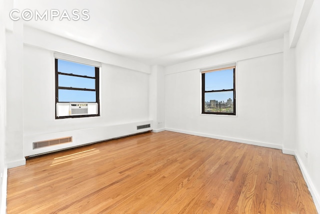 345 W 145th St Unit 8C3, New York City, NY 10031 - spare room with cooling unit, wood finished floors, and plenty of natural light