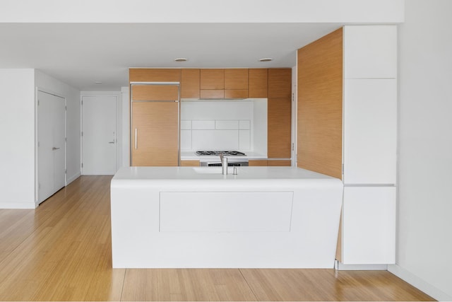 2 River Ter Unit 18F, New York City, NY 10282 - kitchen featuring decorative backsplash, light countertops, brown cabinets, and modern cabinets