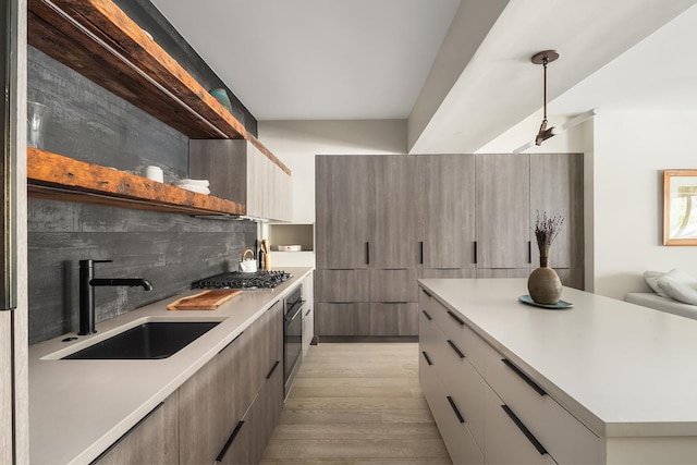 231 10th Ave Unit 5A, New York City, NY 10011 - kitchen with a sink, modern cabinets, stainless steel gas stovetop, and light wood-style floors