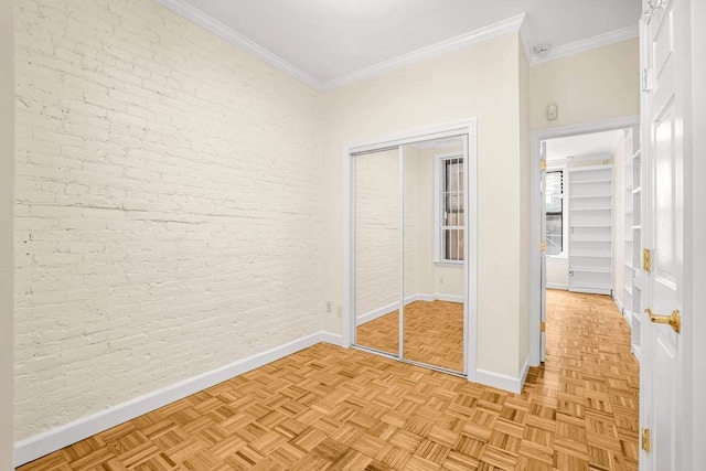 350 W 48th St Unit 1W, New York City, NY 10036 - unfurnished bedroom with baseboards, ornamental molding, brick wall, and a closet