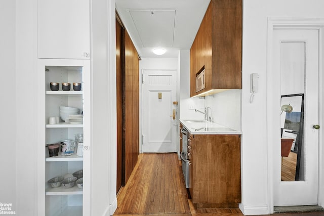 25 Tudor City Pl Unit 2101, New York City, NY 10017 - kitchen featuring light countertops, a sink, brown cabinets, and white microwave