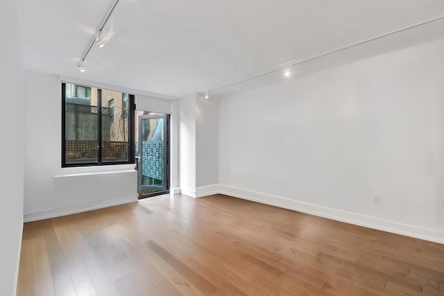 199 Bowery Unit 2D, New York City, NY 10003 - unfurnished room featuring track lighting, wood finished floors, and baseboards