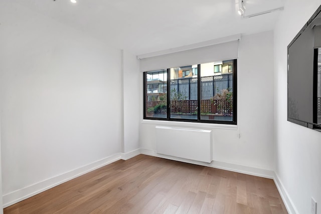 199 Bowery Unit 2D, New York City, NY 10003 - unfurnished room with wood finished floors, radiator heating unit, and baseboards