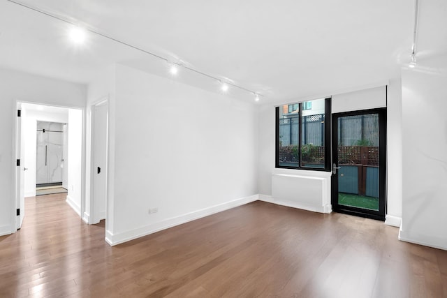 199 Bowery Unit 2D, New York City, NY 10003 - empty room with wood finished floors, rail lighting, and baseboards