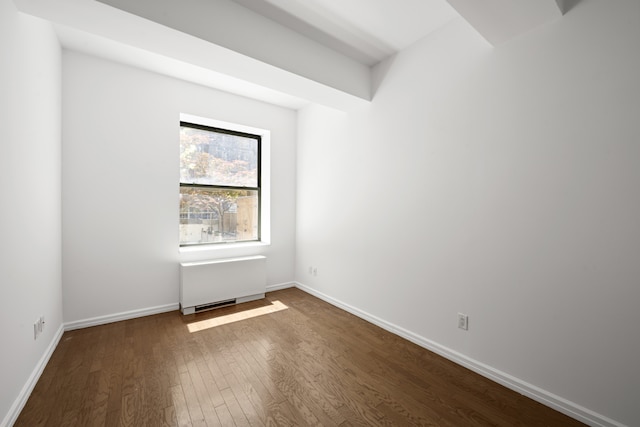 99 John St Unit 1405, New York City, NY 10038 - empty room featuring dark wood finished floors, radiator, and baseboards