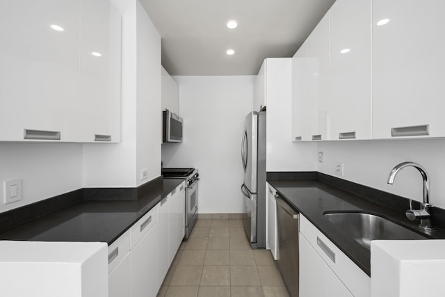 99 John St Unit 1405, New York City, NY 10038 - kitchen featuring stainless steel appliances, modern cabinets, dark countertops, a sink, and white cabinetry