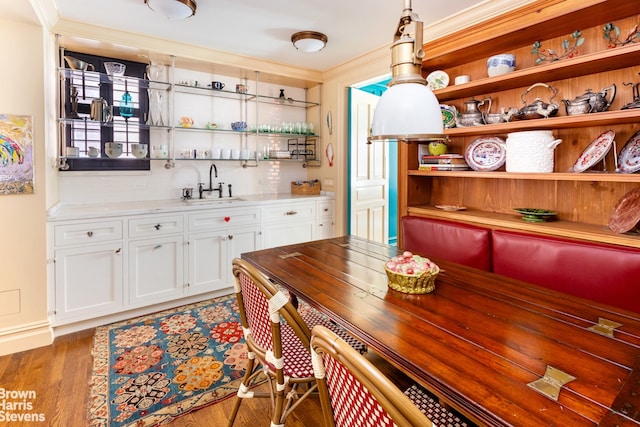 2 Beekman Pl Unit 5Ag, New York City, NY 10022 - dining space featuring bar with sink, crown molding, and wood finished floors