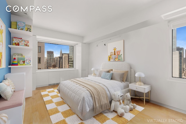 303 E 57th St Unit 33Ef, New York City, NY 10022 - bedroom featuring wood finished floors and a city view