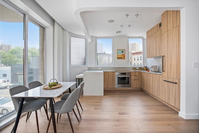 128 Woodpoint Rd Unit 2, New York City, NY 11211 - kitchen featuring oven, modern cabinets, light brown cabinetry, and light wood-style floors