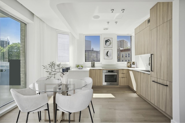 128 Woodpoint Rd Unit 2, New York City, NY 11211 - kitchen featuring stainless steel oven, modern cabinets, light brown cabinetry, light wood-style flooring, and light countertops