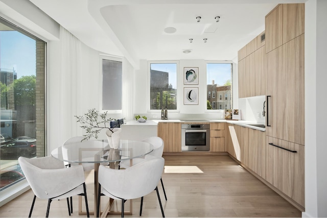 128 Woodpoint Rd Unit 2, New York City, NY 11211 - kitchen featuring modern cabinets, oven, light brown cabinetry, light wood-style flooring, and light countertops