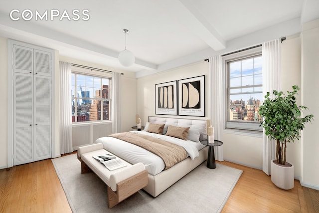 45 Christopher St Unit 12/14F, New York City, NY 10014 - bedroom with light wood-style flooring, beamed ceiling, and baseboards