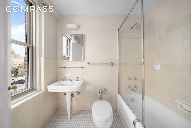 45 Christopher St Unit 12/14F, New York City, NY 10014 - full bath featuring tile walls, shower / bathtub combination, a sink, a wainscoted wall, and toilet