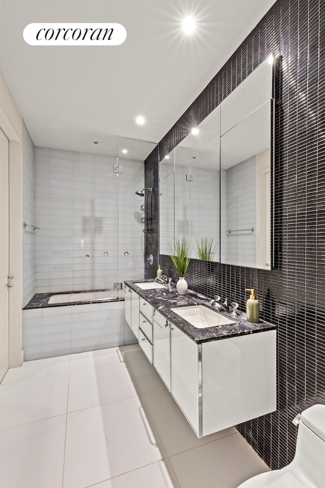 25 Broad St Unit 6M, New York City, NY 10004 - full bath featuring tile walls, double vanity, tile patterned floors, a relaxing tiled tub, and tiled shower