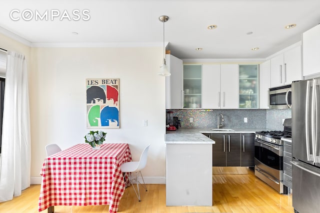 3001 Fort Hamilton Pkwy Unit 3B, New York City, NY 11218 - kitchen with appliances with stainless steel finishes, a sink, crown molding, backsplash, and light wood-style flooring
