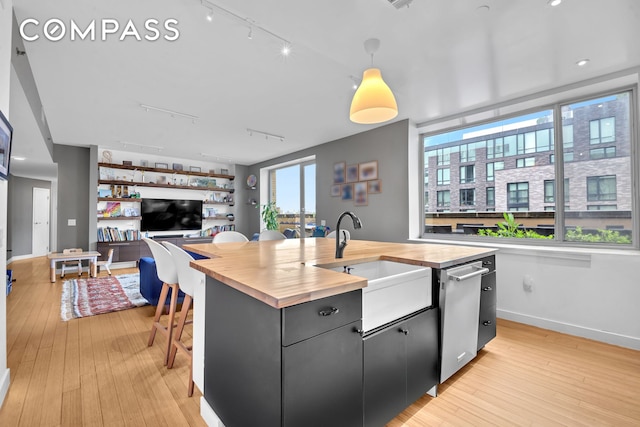 40 W 116th St Unit A907, New York City, NY 10026 - kitchen featuring wood counters, an island with sink, a sink, and track lighting