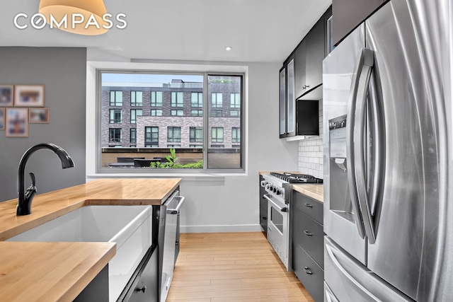 40 W 116th St Unit A907, New York City, NY 10026 - kitchen with appliances with stainless steel finishes, wood counters, a sink, baseboards, and light wood-type flooring